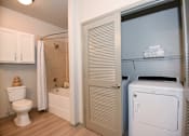 Thumbnail 9 of 28 - A white toilet sits in a bathroom next to a white cabinet.