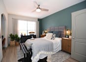 Thumbnail 6 of 28 - A bedroom with a bed, a chair, a ceiling fan, and a window.