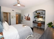Thumbnail 8 of 28 - A bedroom with a bed, desk, and a painting of a bull on the wall.
