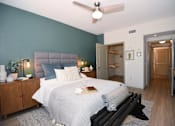 Thumbnail 7 of 28 - A bedroom with a bed, nightstands, and a ceiling fan.