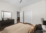 Thumbnail 3 of 42 - A bedroom with a bed, dresser, and mirror.