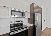 Thumbnail 24 of 42 - A modern kitchen with a stainless steel refrigerator and oven.