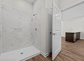 Thumbnail 33 of 42 - A bathroom with a marble tile shower and a white bathtub.
