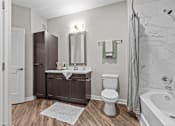 Thumbnail 22 of 39 - A bathroom with a toilet, sink, and bathtub.