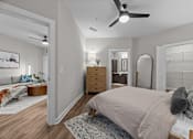 Thumbnail 21 of 39 - A bedroom with a bed, dresser, mirror, and a ceiling fan.