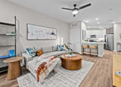 Thumbnail 19 of 39 - A living room with a grey couch and a coffee table.