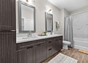 Thumbnail 16 of 39 - A modern bathroom with a double sink vanity and a shower area.