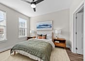 Thumbnail 8 of 39 - A bedroom with a bed, nightstands, and a ceiling fan.