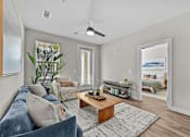 Thumbnail 7 of 39 - A living room with a blue couch and a wooden coffee table.