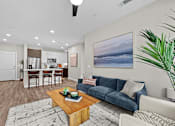 Thumbnail 3 of 39 - A living room with a blue couch and a painting on the wall.
