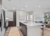 Thumbnail 2 of 39 - A modern kitchen with a refrigerator on the left and a dining area with a blue couch.