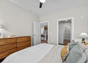 Thumbnail 15 of 39 - A bedroom with a bed, dresser, and two doors.