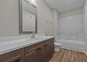 Thumbnail 33 of 39 - A bathroom with a marble shower and wooden cabinets.