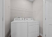Thumbnail 38 of 39 - Two white washing machines in a small laundry room.