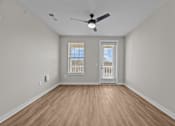 Thumbnail 32 of 39 - A room with a ceiling fan and wooden flooring.