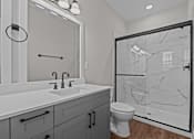 Thumbnail 19 of 37 - A bathroom with a marble shower and a white sink.