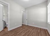 Thumbnail 16 of 37 - A room with wooden flooring and white walls.