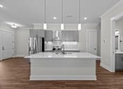 Thumbnail 13 of 37 - A modern kitchen with a large island and pendant lights.