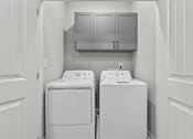 Thumbnail 10 of 37 - A white washing machine and dryer in a laundry room.