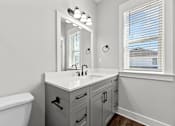 Thumbnail 9 of 37 - A bathroom with a white sink and a large mirror.