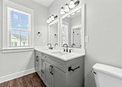 Thumbnail 6 of 37 - A bathroom with a white tub, a large mirror, and a window with blinds.