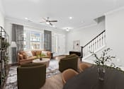 Thumbnail 1 of 37 - A living room with a brown sofa, a coffee table, and a staircase.