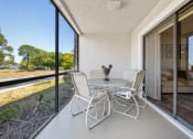 Thumbnail 27 of 27 - a patio with a table and chairs and a large window