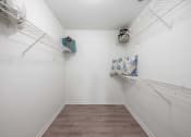 Thumbnail 26 of 27 - a spacious room with white walls and two shelves on the wall and a closet with