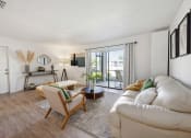 Thumbnail 13 of 27 - a living room with a white couch and a sliding glass door