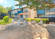 Thumbnail 21 of 21 - a patio with a grill and chairs in front of an apartment building