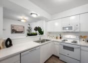 Thumbnail 22 of 27 - a kitchen with white appliances and white cabinets and a sink