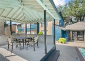 Thumbnail 19 of 21 - a patio with a table and chairs and a pool