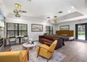 Thumbnail 7 of 27 - a living room with couches and chairs and a pool table