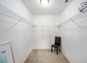 Thumbnail 17 of 27 - a bedroom with white walls and a white chair in the corner of the room