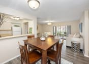Thumbnail 12 of 27 - a dining area with a wooden table and chairs and a living room with a couch and a