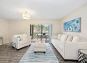 Thumbnail 11 of 27 - a living room with two white couches and a blue rug