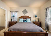 Thumbnail 35 of 39 - A bedroom with a large bed and a wooden headboard.