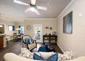Thumbnail 25 of 39 - A living room with a white ceiling fan and a white couch with blue and white pillows.