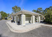 Thumbnail 18 of 39 - A small building with a flag on top is surrounded by a metal fence.