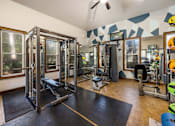 Thumbnail 9 of 39 - A gym with a variety of equipment including a squat rack, bench, and weights.