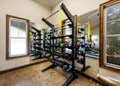 Thumbnail 12 of 39 - A home gym with a squat rack and dumbbells.
