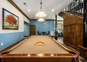 Thumbnail 7 of 39 - A pool table in a room with a blue wall and a painting of a tree.