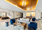 Thumbnail 25 of 26 - A large room with a long white couch and a wooden ceiling.