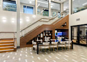Thumbnail 24 of 26 - A modern interior with a staircase and a dining table.