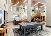 Thumbnail 23 of 26 - A pool table is in the middle of a room with a staircase in the background.