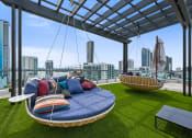 Thumbnail 7 of 66 - a lounge area with couches and chairs on a roof top with a view of the city