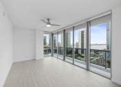 Thumbnail 37 of 66 - an empty living room with a ceiling fan and a view of the city
