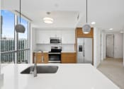 Thumbnail 46 of 66 - a kitchen with white countertops and a large window