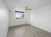 Thumbnail 55 of 66 - a bedroom with hardwood floors and a large window