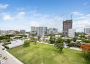Thumbnail 58 of 66 - an aerial view of a grassy area with a tall building under construction in the background